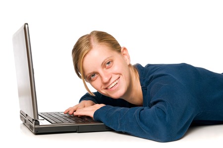 Detail of an happy cute blonde girl on a laptop computer looking at camera, isolated on white backgroundの写真素材