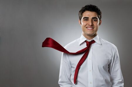 Young businessman smiling at camera with blowing necktie. Good business in action!の写真素材