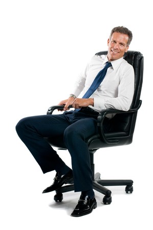 Smiling confident businessman sitting on chair and looking at camera isolated on white backgroundの写真素材