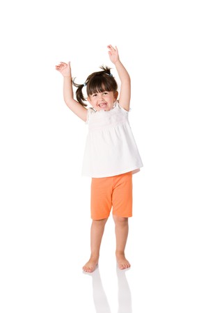 Little joyful girl with arms raised isolated on white backgroundの写真素材