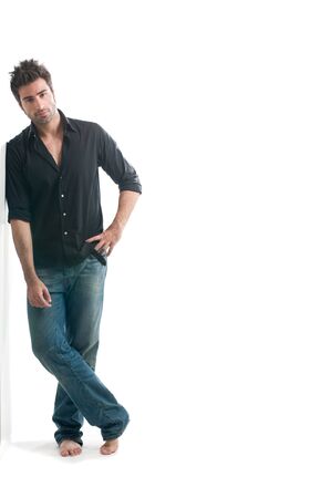 Smiling young latin man leaning against a white wall with copy space for your text isolated on white backgroundの写真素材