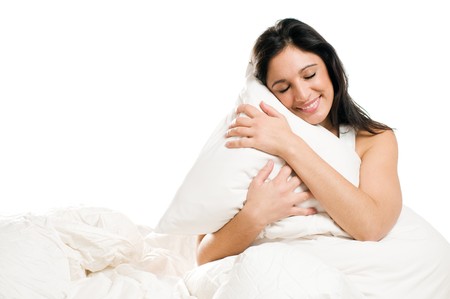 Young woman embracing her pillow in the morning isolated on white backgroundの写真素材
