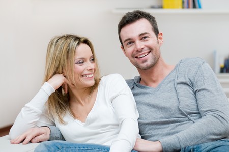Young happy couple smiling with joy at camera in their homeの写真素材