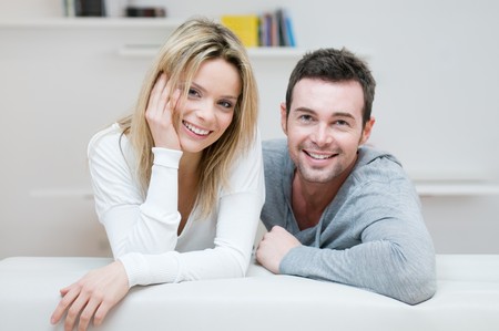 Young happy couple smiling together at camera in their homeの写真素材