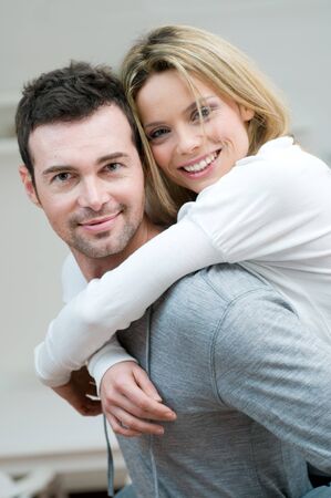 Young couple piggybacking and have fun at homeの写真素材