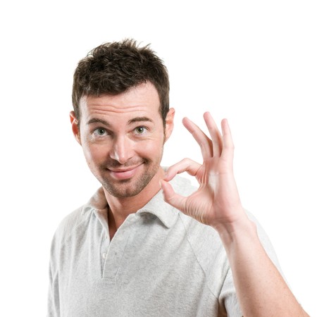 Satisfied young man showing okay sign isolated on white backgroundの写真素材