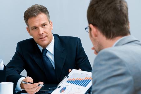 Mature businessman showing growing chart in a meeting discussion at officeの写真素材