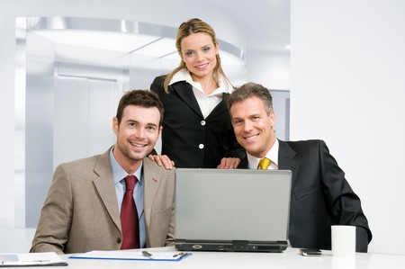 Smiling happy business team looking at camera together in their modern officeの写真素材