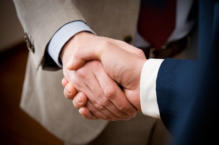 Two professional businessman giving handshake in the office, closeup selective focusの写真素材