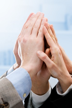 Group of hands raised up for an high five in the office. Symbol of teamwork, victory and successの写真素材