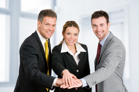 Happy smiling business team holding hands in a heap, good teamwork jobの写真素材