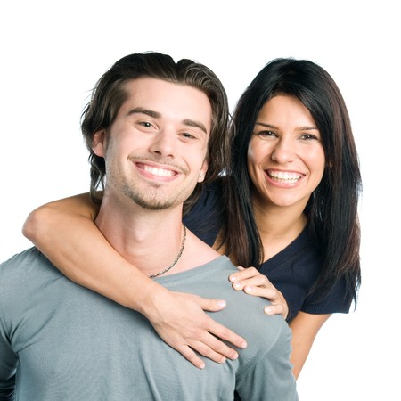 Happy smiling young latin couple piggyback isolated on white backgroundの写真素材