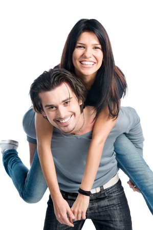Happy young latin couple smiling and playing piggyback isolated on white backgroundの写真素材