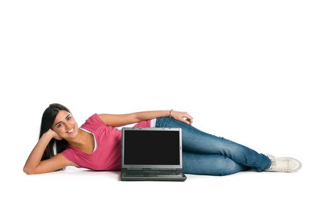 Happy young beautiful lady laying down with laptop and blank screen for your text, isolated on white backgroundの写真素材