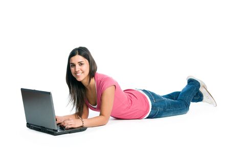 Happy smiling latin girl working adn surfing on laptop isolated on white backgroundの写真素材
