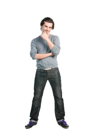 Happy thinking young man with positive expression standing full length isolated on white backgroundの写真素材