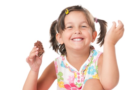 Happy joyful little girl eating chocolate bar for snack isolated on white backgroundの写真素材