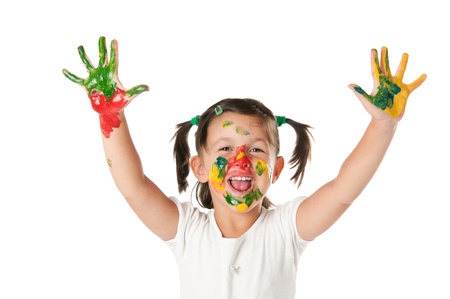 Happy joyful little girl playing with colors in her hands and face isolated on white backgroundの写真素材