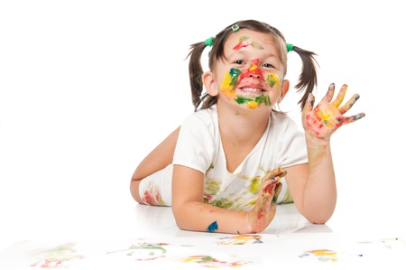 Happy smiling little girl playing with colors and waving hello isolated on white backgroundの写真素材