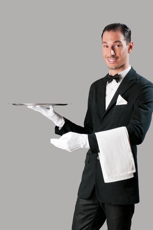 Professional waiter serving with empty stainless tray, perfect for your productの写真素材
