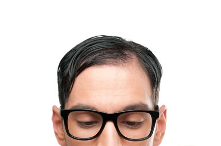 Close up nerd face looking down behind a white sign board isolated on white backgroundの写真素材