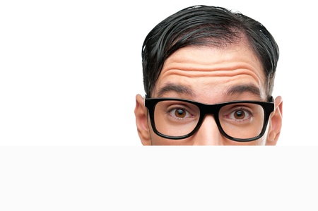 Close up of surprised nerd behind a white sign board isolated on white backgroundの写真素材
