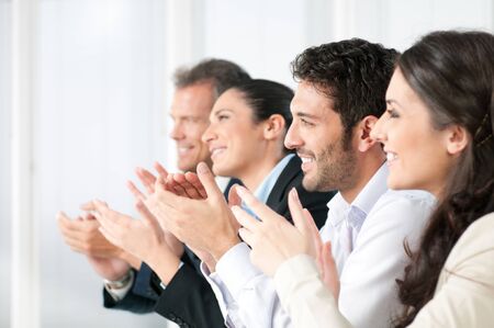 Happy smiling business team clapping hands during a meeting in officeの写真素材