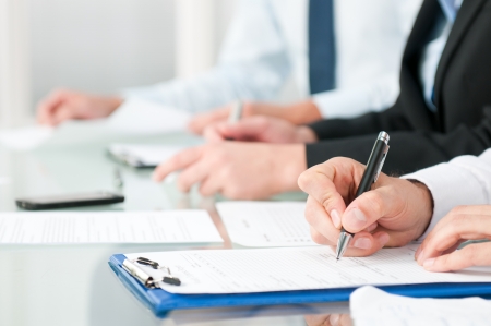 Close up shot of people compiling forms during a business conferenceの写真素材