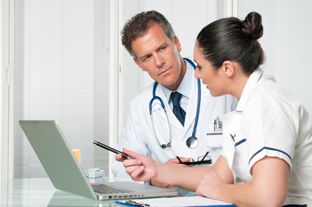 Mature doctor and his female discussing together a medical exam at clinic hospitalの写真素材