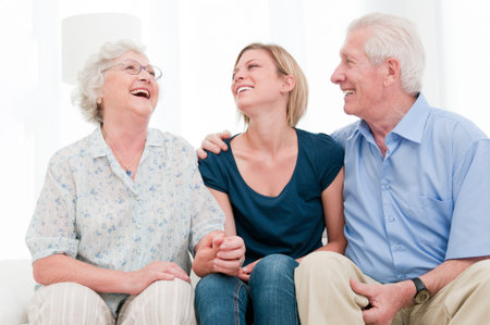 Happy smiling girl staying together with her grandparents at home