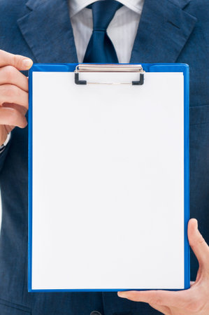 Business man in suit holding a blank clipboard ready for your text or imageの写真素材
