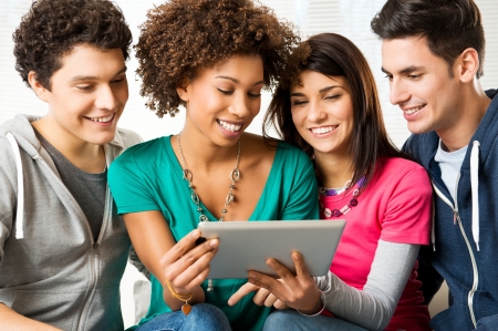 Young Happy Friends Playing and Looking At Digital Tablet Young Happy Friends Playing and Looking At Digital Tablet