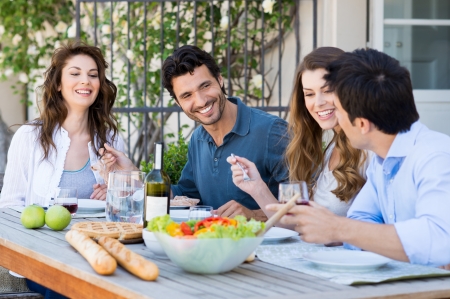 Group Of Happy Friends Having Dinner At Patio