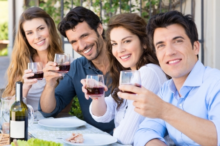 Portrait Of Happy Young Group Friends Holding Wine Glass Outdoor