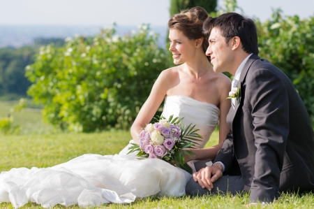 Portrait Of Happy Married Young Couple Sitting On The Grassの写真素材