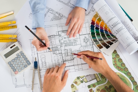 Close Up Of Two Architects Discussing Plan Together At Desk With Blueprintの写真素材