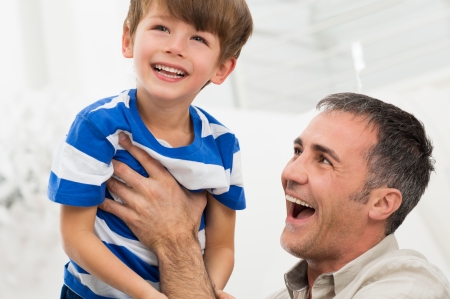 Portrait Of Happy Father Raises His Son In The Airの写真素材