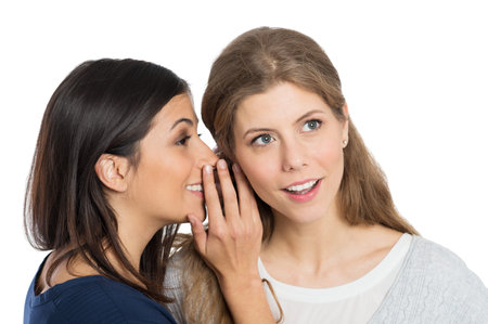 Young Woman Speak Into The Ear Into Ear Of Her Friend