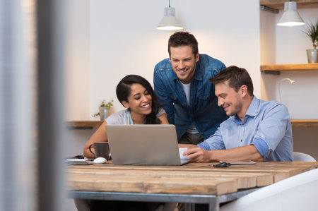 Coworkers smiling together while going through paperwork in office