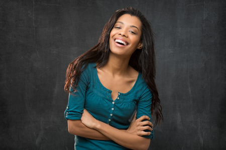 Portrait of smiling young woman with armcrossed looking at cameraの写真素材