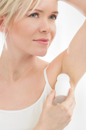 Closeup of young woman applying deodorant to her armpitの写真素材