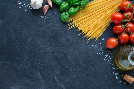 Spaghetti, tomatoes and others ingrdients for italian pasta on blackboardの写真素材