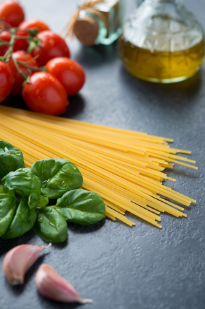 Fresh ingredients to make pasta with tomato sauce on blackboardの写真素材