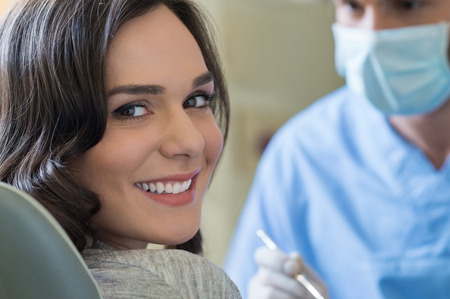 Smiling young woman receiving dental checkup