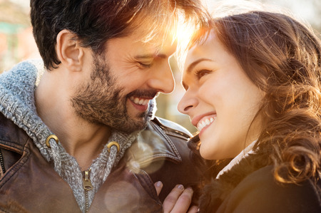 Portrait of happy young couple looking at each other and smiling outdoorの写真素材