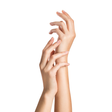 Close up of woman's hands isolated on white background. Closeup shot of a woman applying moisturizer on her hand. Beautiful woman's hands gesturing with care.の写真素材