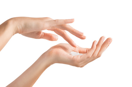 Closeup shot of beautiful female hands holding and applying moisturiser. Beauty woman's hand applying cream. Hands isolated on white backgroundの写真素材