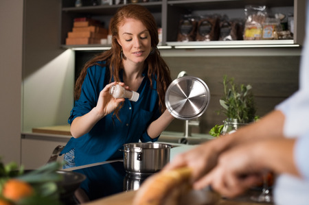 Happy young couple baking and cooking meal at kitchen.の写真素材