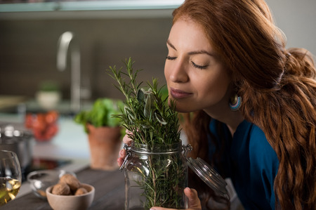 Happy young woman enjoying the fragrance of plants.の写真素材