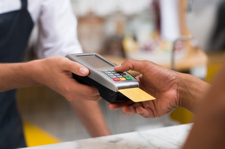 Close up of hand using credit card swiping machine to pay. Hand with creditcard swipe through...